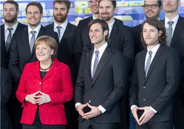 Die Handballer Uwe Gensheimer (Mitte) und Johannes Sellin (rechts) haben sich beim Fototermin mit Angela Merkel einen kleinen Spaß erlaubt.