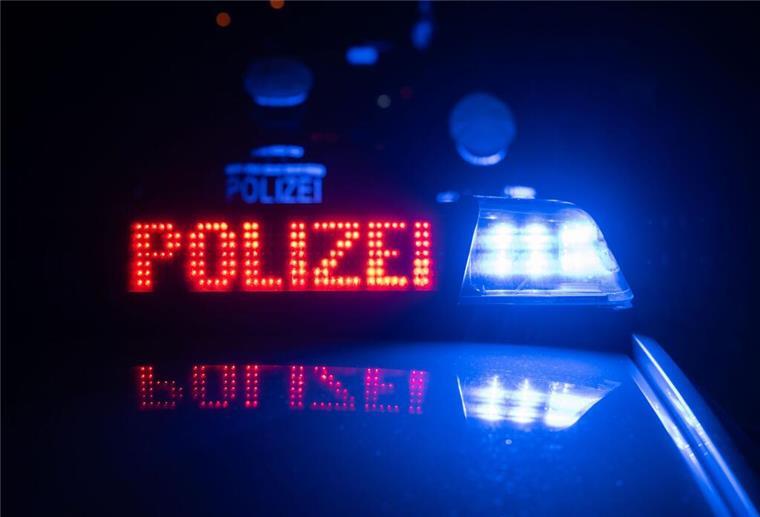 Zwei Polizisten stehen im Rahmen eines Fototermins vor einem Polizeifahrzeug.