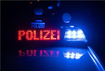 Zwei Polizisten stehen im Rahmen eines Fototermins vor einem Polizeifahrzeug.