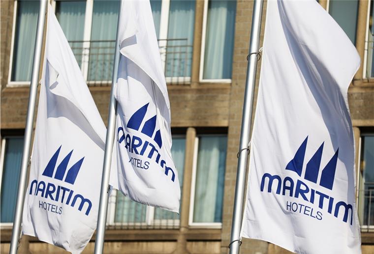 Flaggen mit Maritim-Werbung vor einem Gebäude. Die Hotelkette Maritim befindet sich in einer schwierigen Lage.