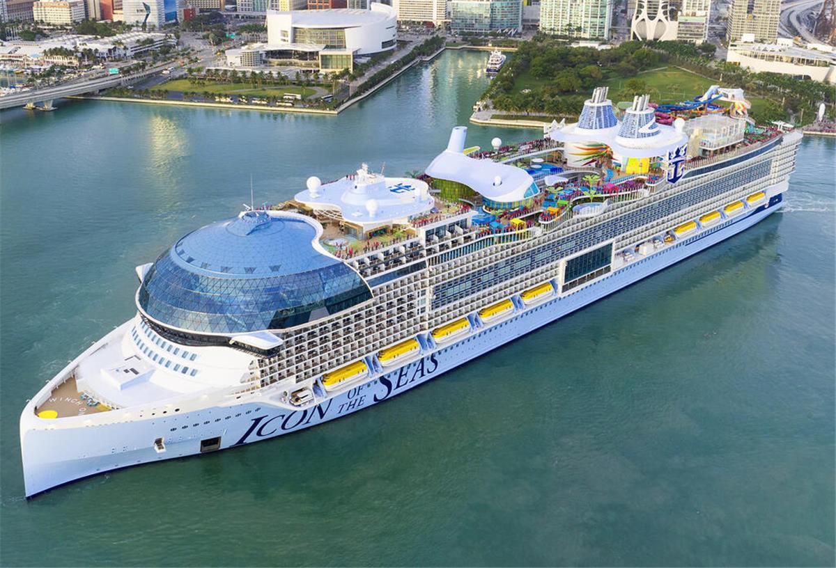 100 Meter länger als die Titanic: Das ist das größte Kreuzfahrtschiff der Welt Die Icon of the Seas liegt im Wasser vor einer Großstadt. Sie ist das größte Kreuzfahrtschiff der Welt.