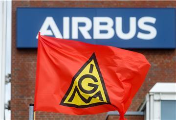 Eine Fahne der IG-Metall weht bei einem Warnstreik vor dem Schriftzug "Airbus" an dem Werk in Hamburg-Finkenwerder.