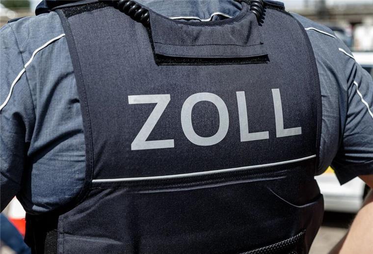 Ein Beamter trägt während seines Dienstes eine Schutzweste mit der Rückenaufschrift "Zoll".