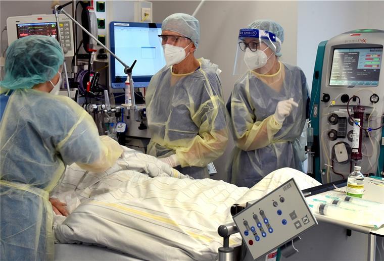 Auf der Corona-Intensivstation vom Evangelischen Krankenhaus Paul Gerhard Stift stehen die Oberärztin Agnieszka Töpper (l), Chefarzt Franz X. Kleber und Schwester Jane am Bett eines Patienten. Das Krankenhaus in Wittenberg hat seine sonst 10 Intensivplätze auf 16 aufgestockt, die gegenwärtig auch alle belegt sind.