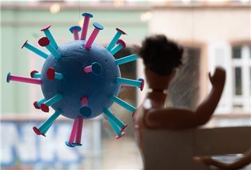 Ein stilisiertes Corona-Virus hängt in einem Schaufenster.