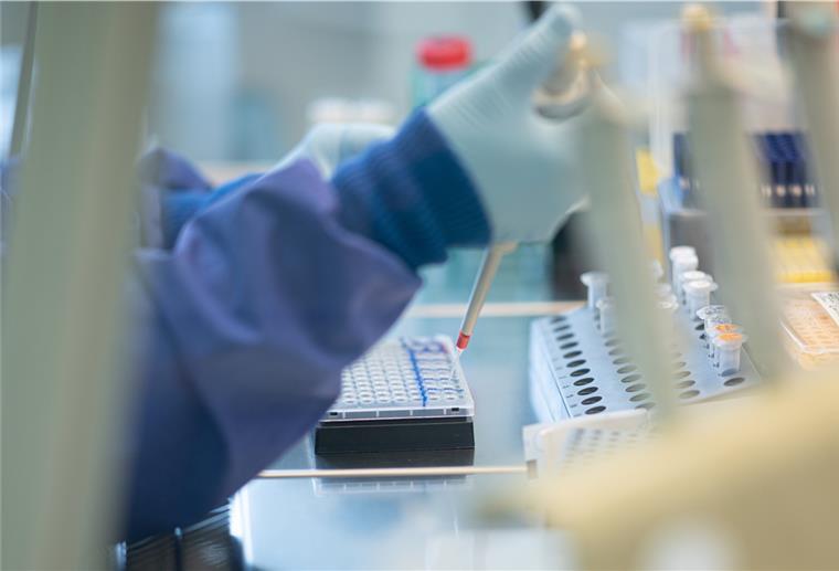 Eine Mitarbeiterin arbeitet an einer Sicherheitswerkbank in einem Labor im Institut für Hygiene und Gesundheit, dabei mischt sie isolierte RNA aus Abwasserproben mit PCR-Reagentien für die spezifische Detektion von SARS-CoV-2