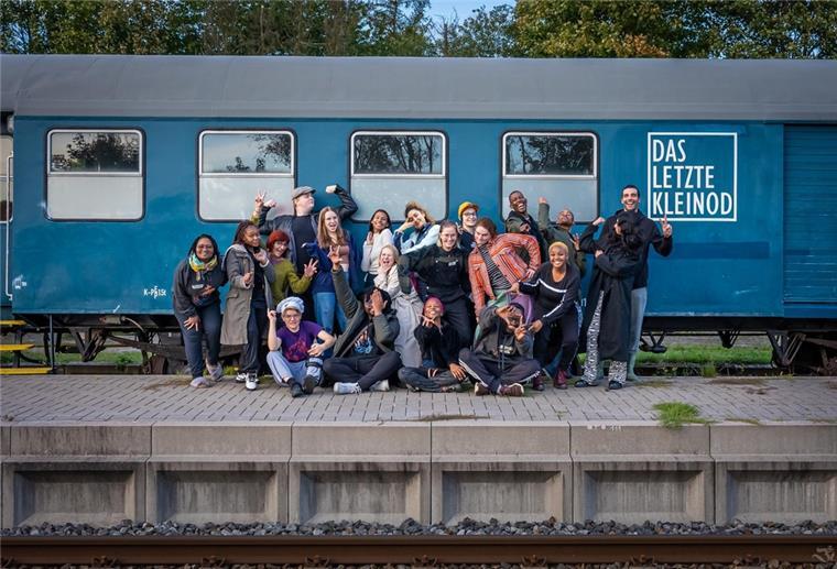 Die Jugendlichen am Bahnhof Geestenseth vor dem Ozeanblauen Zug.
