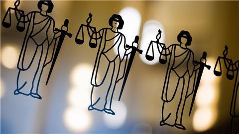 Die Justitia ist an einer Scheibe am Eingang zum Oberlandesgericht zu sehen.