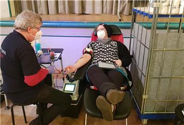 Die Kanüle steckt in der Armbeuge, es kann losgehen: Reporterin Nicole Böning mit DRK-Teamleiter Hans-Peter Mennen.