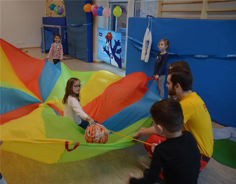 Die Kinder der Kita Regenbogen in Schiffdorf durften mit Iwo Schulz von der DLRG Wehdel (rechts) auch spielerisch das Retten von Menschen üben. Hier "rettet" Leon (2. von rechts) die kleine Loreley aus den bunten "Wellen". 
