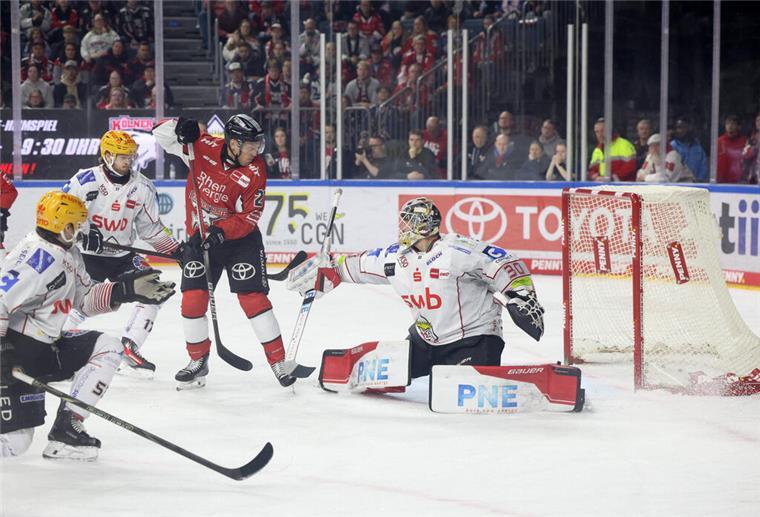 Ein Kölner Eishockeyspieler fälscht eine Scheibe vor dem Bremerhavener Tor ab.