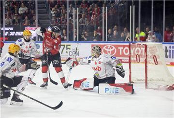Ein Kölner Eishockeyspieler fälscht eine Scheibe vor dem Bremerhavener Tor ab.