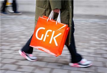 Eine Frau trägt zwei Tüten mit dem Logo des Konsumforschungsunternehmens GfK. 