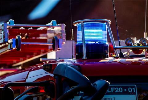 Auf dem Dach eines Einsatzfahrzeugs der Feuerwehr leuchtet ein Blaulicht.