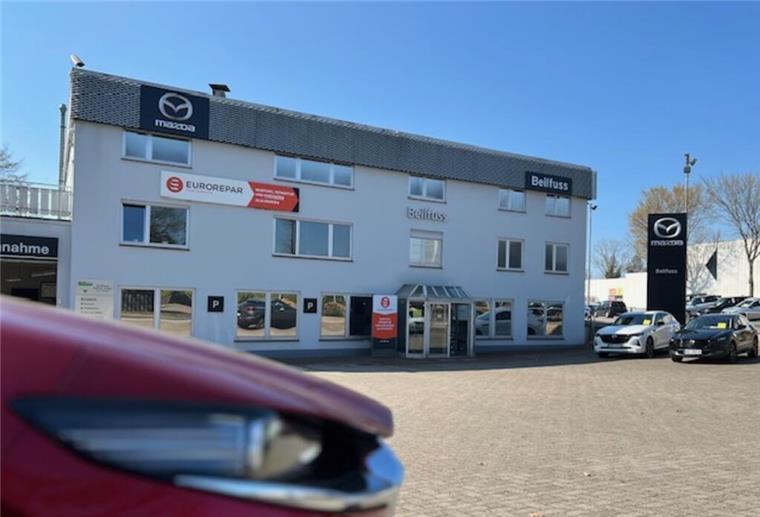 Außenansicht Autohaus Beilfuss mit Front eines Autos.