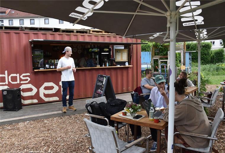 Menschen an Tischen in Gartencafé