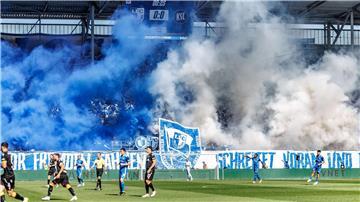 Die Magdeburger Fans zeigen ein fragwürdiges Banner und betonen dies mit Pyrotechnik.