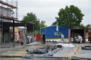 Die Mauern sind eingerüstet, der Platz, wo einst das Reifenlager war, ist mit Planen abgedeckt: Mitarbeiter einer Spezialfirma arbeiten daran, die Spuren des Brandes im Autohaus Manikowski in Bad Bederkesa zu beseitigen.