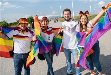 fußball-Fans mit Regenbogenfahnen