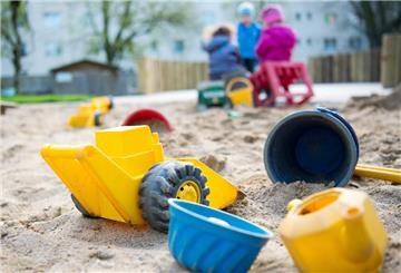 Spielzeug liegt in einem Sandkasten in einer Kindertagesstätte