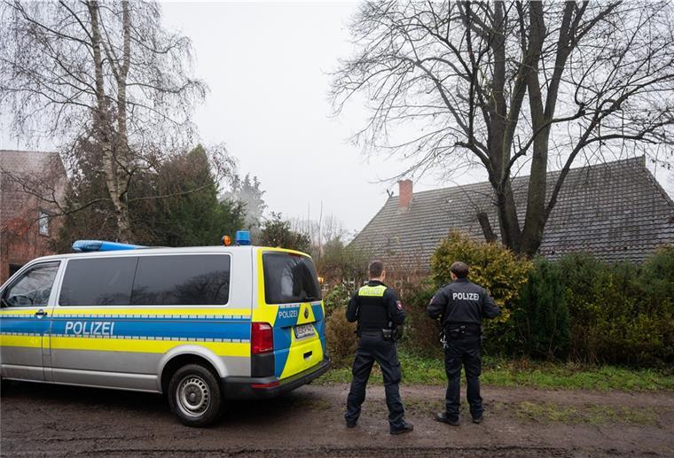 Tote in Fischerhude: Mordkommission durchsucht mehrere Gebäude Zwei Polizisten stehen vor einem Haus in Fischerhude