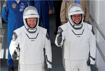 Die NASA-Astronauten Douglas Hurley (links), und Robert Behnken verlassen das Betriebs- und Kassengebäude von Neil A. Armstrong auf dem Weg zur Startrampe 39-A im Kennedy Space Center. 