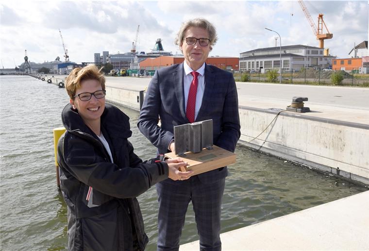 Neue Kaje im Kaiserhafen ist fertig Die neue Kaje ist fertig. Bremenports-Chef Robert Howe schenkt Häfensenatorin Dr. Claudia Schilling ein kleines Stückchen Spundwand.