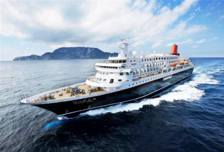 Japanisches Kreuzfahrtschiff „Nippon Maru“ wird außer Dienst gestellt Ein Kreuzfahrtschiff auf dem Meer. Im Hintergrund ist ein Berg zu sehen.
