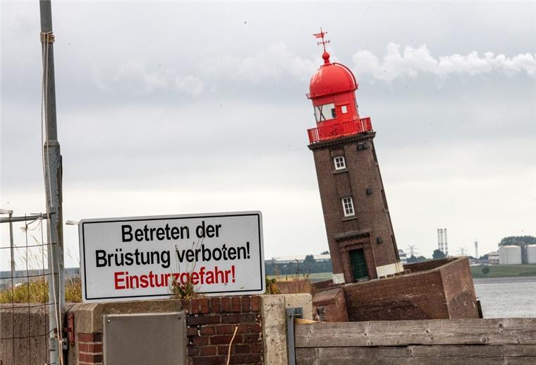 Der kleine Leuchtturm steht in Schieflage, davor steht ein Schild mit der Aufschrift: Betreten der Brüstung verboten! Einsturzgefahr!