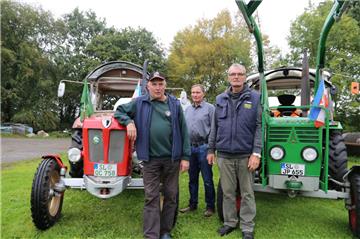 Die Oldtimerfreunde Karl-Heinz Nissen (links) und Jürgen Peper legten auf der Rückfahrt von der Oldtimer-Traktor-WM einen Stopp beim Bekannten Claus Jüchtern in Wehdel. 