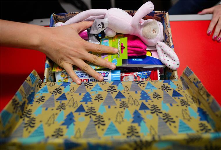 Ein weihnachtlich gestalteter Schuhkarton gefüllt mit Kindersachen.