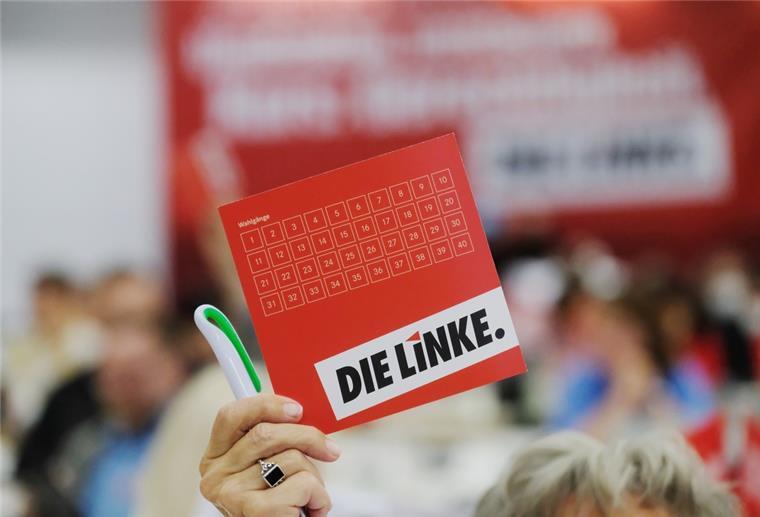 Eine Delegierte des Landesparteitages der Partei Die Linke in Sachsen hält ihre Stimmkarte in die Höhe.