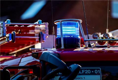 Auf dem Dach eines Einsatzfahrzeugs der Feuerwehr leuchtet ein Blaulicht.