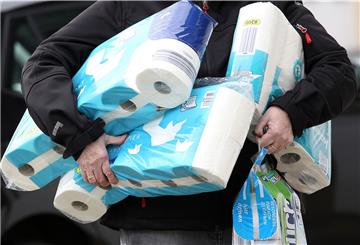 Nordrhein-Westfalen, Siegen: Ein Mann trägt gekauftes Toilettenpapier und Küchenrollen aus einem Supermarkt.