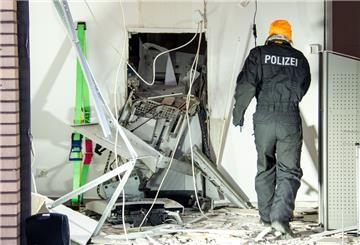 Eine Ermittlerin der Polizei steht in einer Bankfiliale neben einem gesprengten Geldautomat. 