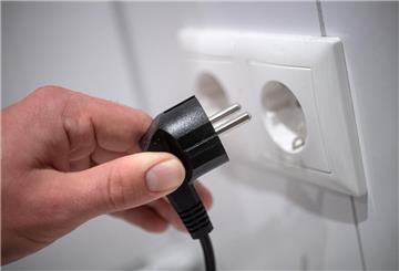 Ein Stecker wird in eine Steckdose gesteckt.