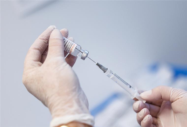 Eine Krankenschwester zieht im Impfzentrum Freising den Impfstoff Nuvaxovid vom Hersteller Novavax auf eine Spritze auf.