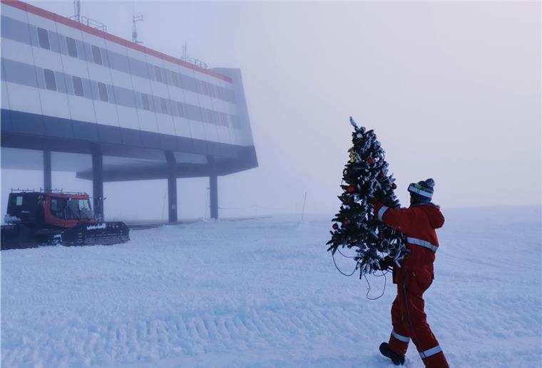 Weihnachtslieder in der Antarktis Ein Weihnachtsbaum aus Plastik wird von einem Überwinterer zur Neumayer-Station gebracht.