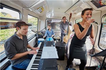 Die Sängerin Beatrice Asare-Lartey tritt mit ihrer Band (Noah Rott am E-Piano, Nathan Ott am Schlagzeug und Axel Burkhardt am Bass) während ihres Jazztrain-Konzerts in einer U-Bahn in Hamburg auf.