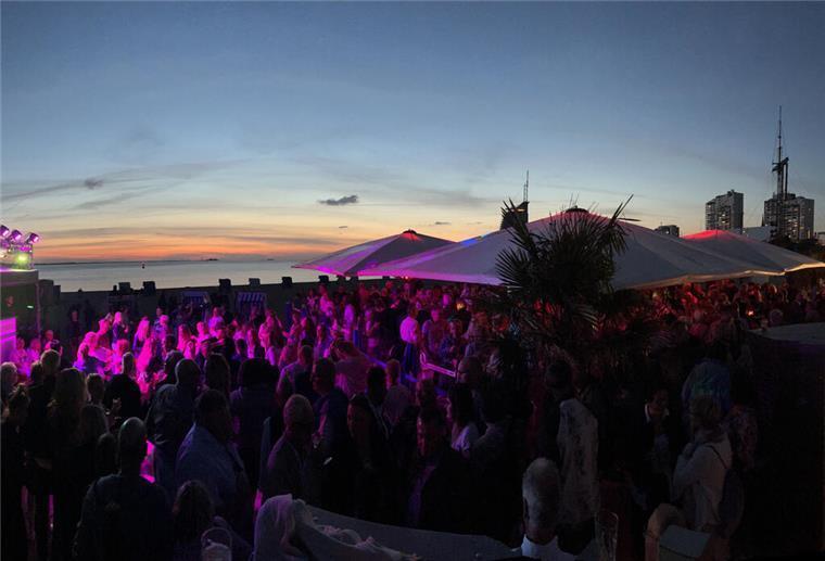Menschen auf Open-Air-Party an der Weser vor Bremerhavens Skyline