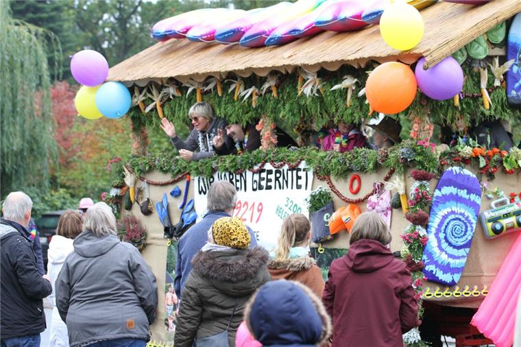 Die Schaulustigen am Straßenrand bestaunen die vorbeiziehenden geschmückten Wagen. Sie alle bringen ihre Botschaften auf die Straße.