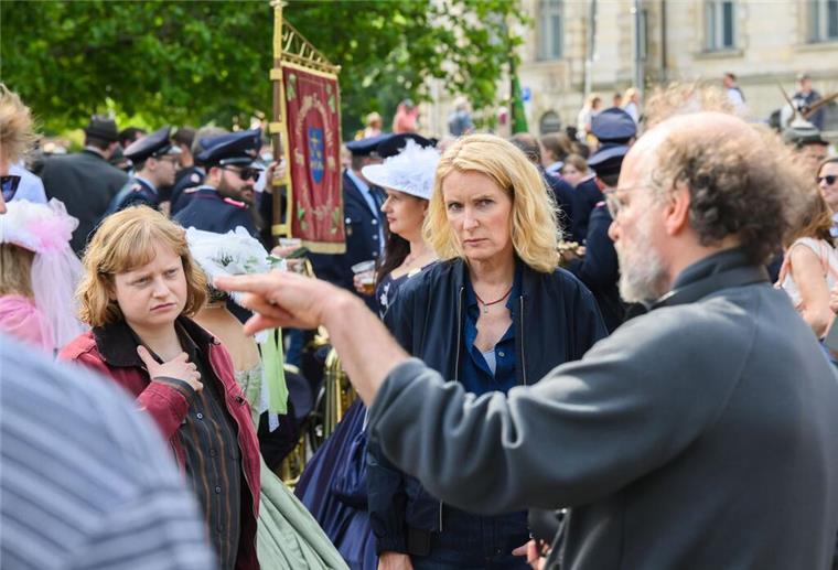 Die Schauspielerinnen Luise von Stein (l) und Maria Furtwängler stehen bei Dreharbeiten für einen neuen fiktiven „Tatort“ inmitten des realen Schützenausmarsches am Neuen Rathaus.
