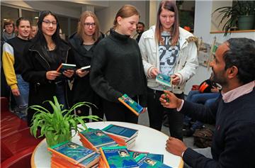 Die Schüler des Gymnasiums standen Schlange, um sich ihre Bücher vom Autor signieren zu lassen.