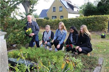 Die Schülerinnen (von links) Jasmin Wagner, Luisa Garms, Gaureka Selvaratnam und Abelina Stelling besuchen auf dem Beverstedter Friedhof die Gedenkstätte für das Euthansie-Opfer Käthe Spreen. Sie wurde von den Nationalsozialisten ermordet. Der ehemalige Lehrer und Bürgermeister Martin Bensen führte die Schülerinnen durch Beverstedt.