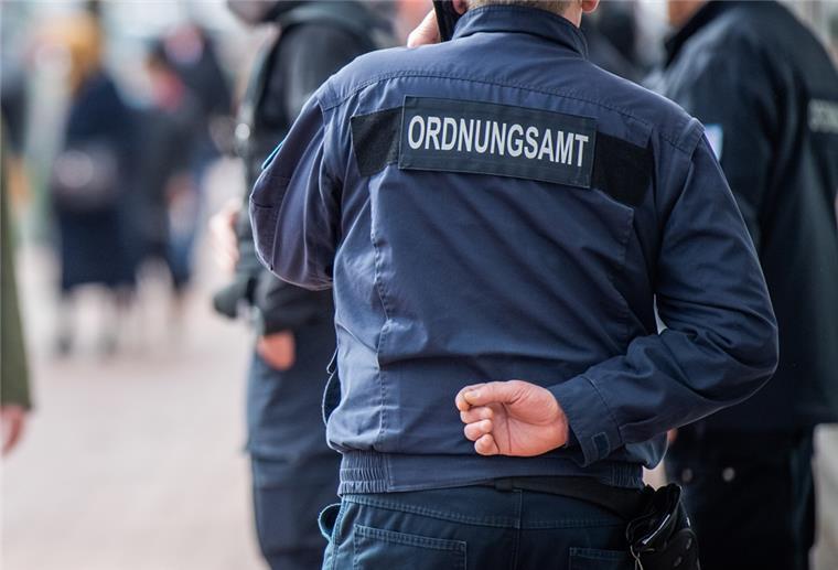 Mann mit Jacke "Ordnungsamt" mit Rücken zur Kamera. 