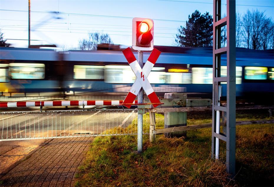Ein Nahverkehrszug passiert einen Bahnübergang an der zweigleisigen Bahnstrecke nahe Ihrhove