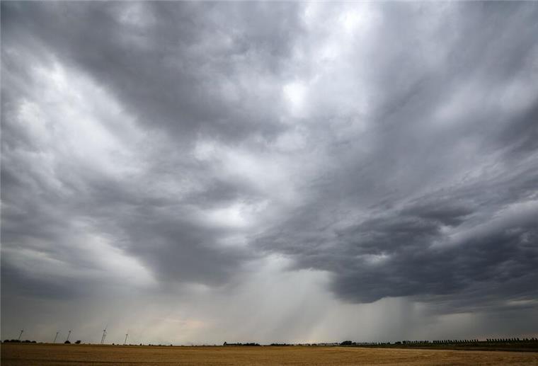 Starkregen, Sturmböen und Gewitter! Jetzt kommt der Wetterumschwung Eine Regenfront zieht über ein Getreidefeld hinweg.