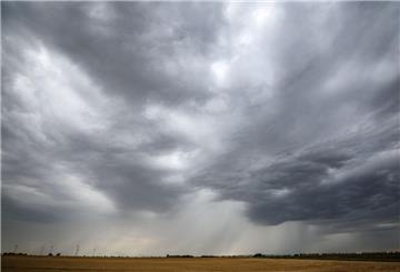  Eine Regenfront zieht über ein Getreidefeld hinweg. 