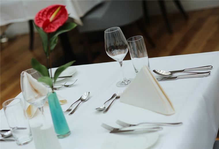 Ein eingedeckter Tisch wartet in einem Restaurant auf Gäste.