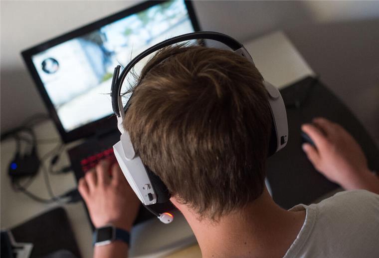 Niedersachsen: Immer mehr Menschen sind internetsüchtig Ein junger Mann sitzt mit einem Headset vor einem Laptop und spielt ein Online-Computerspiel